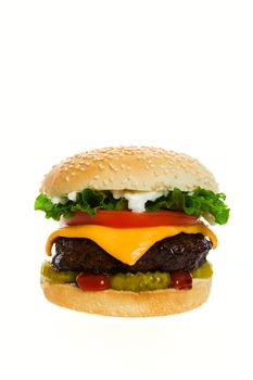 Juicy Angus beef burger topped with cheese, tomatoes & lettuce on a golden sesame seed bun.  Shot on white background.