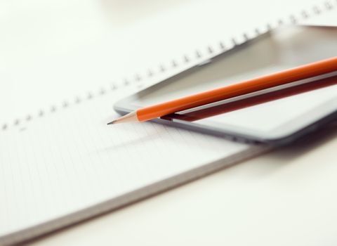 Tablet PC, blank papers and pen on the table.