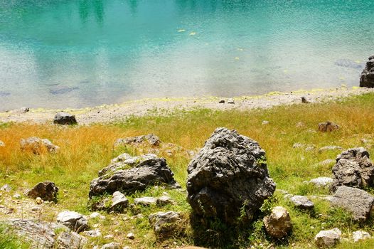 Wasser und Stein am Karersee in den Dolomiten in Südtirol