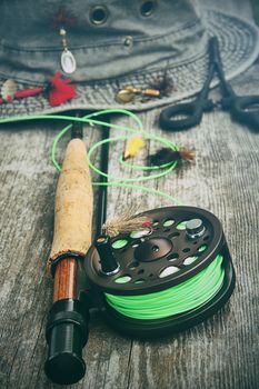 Fly fishing reel with old hat and equipment on bench 