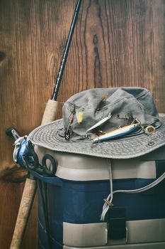 Hat with fishing equipment against wood wall