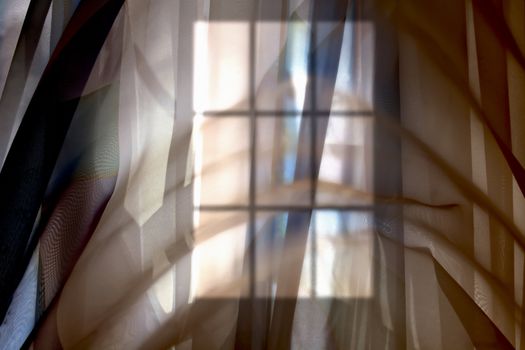 Abstract blurred silhouette of a window behind the transparent curtain