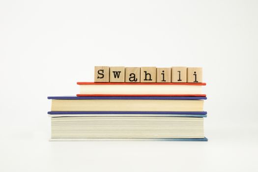 swahili word on wood stamps stack on books, foreign language and translation concept