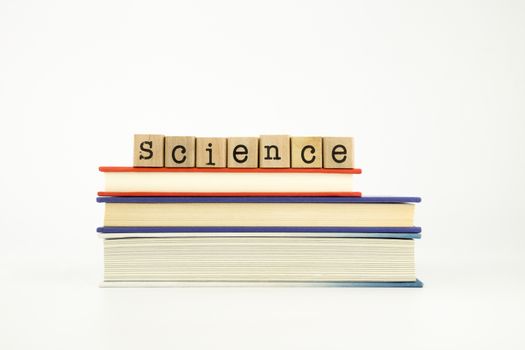 science word on wood stamps stack on books, knowledge and academic concept