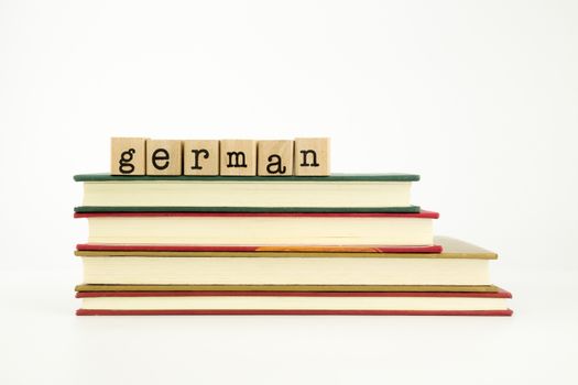 german word on wood stamps stack on books, foreign language and translation concept