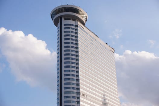 Modern skyscraper,the exterior is glass overlooking the outside. The top is a round tower.                               