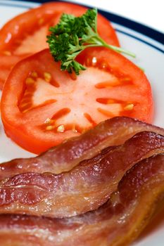 Wavy strips of bacon with tomatoes.
