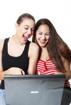 Two girls laughing and surfing the internet together.