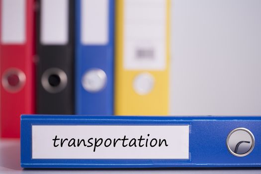 The word transportation on blue business binder