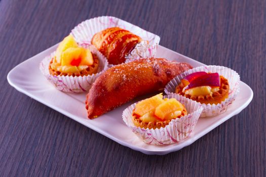 Pastries over a white ceramic plate, over wooden table