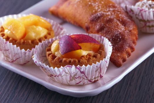 Pastries over a white ceramic plate, over wooden table