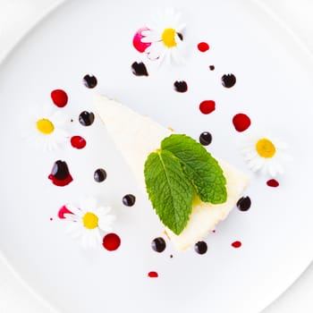 Dessert - Cheesecake with Green Mint decorated with dasiy flowers and decorated with fruit syrup drops.