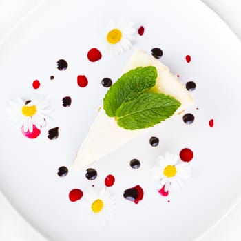 Dessert - Cheesecake with Green Mint decorated with dasiy flowers and decorated with fruit syrup drops.