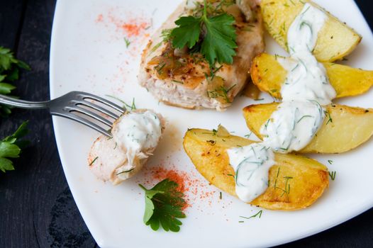 grilled chicken breast with roasted potatoes on white plate