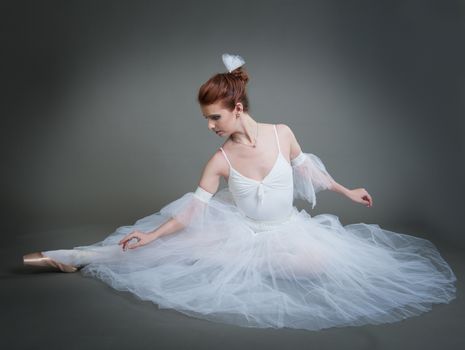 dancer in the white tutu dancing on a grey background