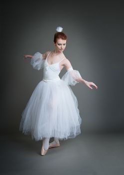 dancer in the white tutu dancing on a grey background