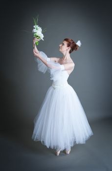 dancer in the white tutu dancing on a grey background