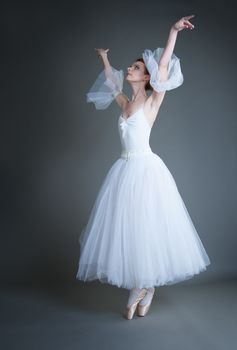 dancer in the white tutu dancing on a grey background