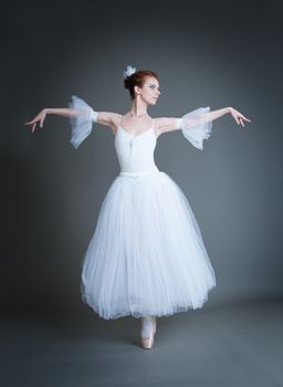 dancer in the white tutu dancing on a grey background