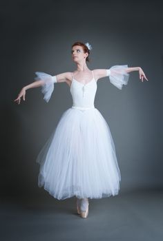 dancer in the white tutu dancing on a grey background