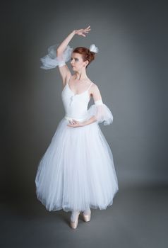 dancer in the white tutu dancing on a grey background