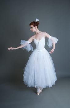 dancer in the white tutu dancing on a grey background