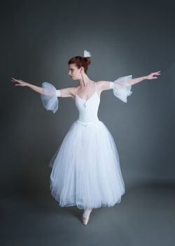 dancer in the white tutu dancing on a grey background