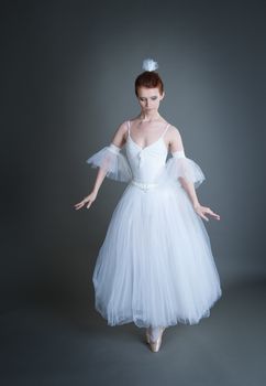 dancer in the white tutu dancing on a grey background