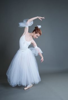 dancer in the white tutu dancing on a grey background