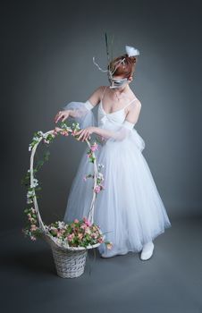 ballerina in the mask and with a basket of flowers