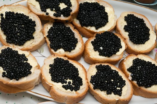 Sandwiches with black caviar lying on a dish