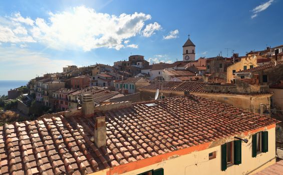 Capoliveri village against the sun, with the characteristic roofs, Elba Island, Italy