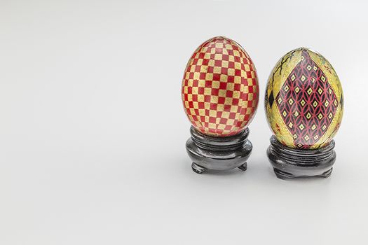 Meticiulously painted eggs with checkers and designs on shiny bases. 