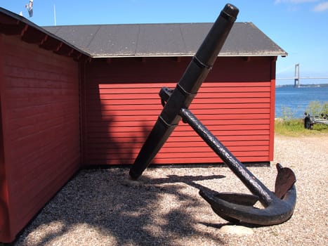  Old iron anchor with ocean in the background                              