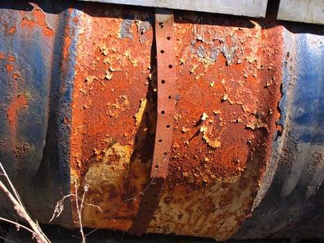 Grunge abstract background metal barrel painted blue and full of rust                 