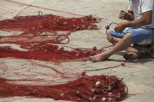 Fisherman repairs his net in Gallipoli (Le)