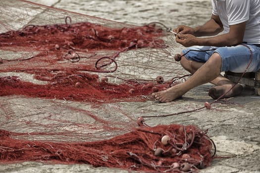 Fisherman repairs his net in Gallipoli (Le)