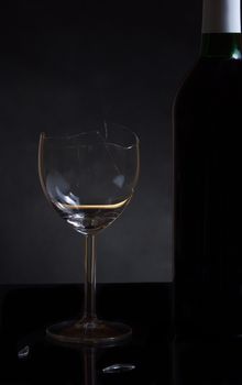 Vine bottle and broken glass on dark background