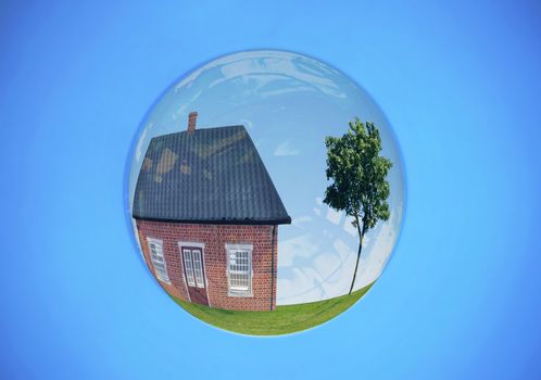 House on a hill with a tree inside a large soap bubble