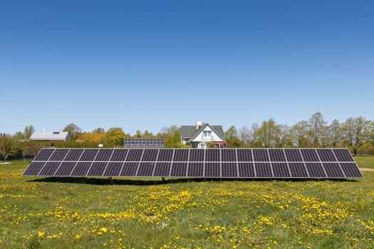 A set of dark blue solar panels in a grass field