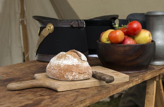 fresh bread and red tomatoes with soldiers caps on the background