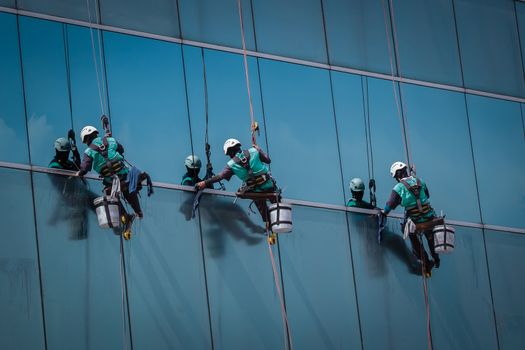 group of workers cleaning windows service on high rise building