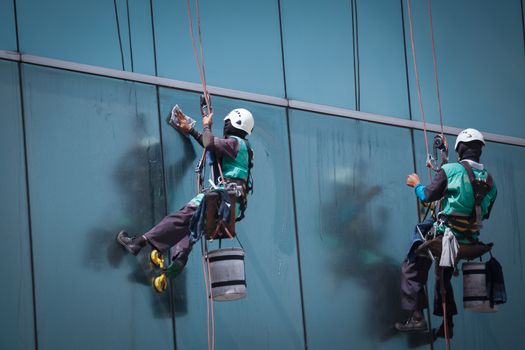 group of workers cleaning windows service on high rise building