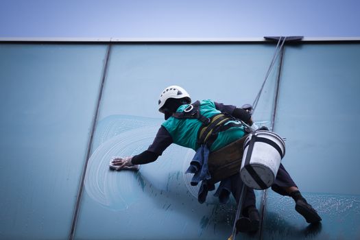 group of workers cleaning windows service on high rise building