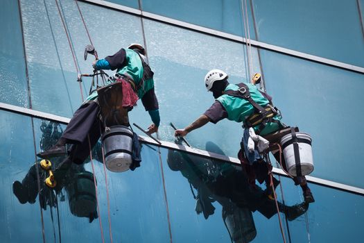 group of workers cleaning windows service on high rise building
