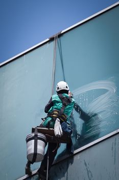 group of workers cleaning windows service on high rise building