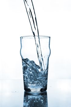 glass with water pouring on glass table