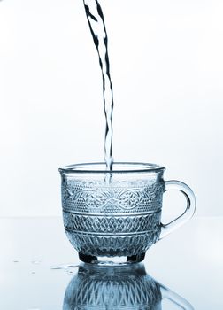 cup glass with water pouring on glass table