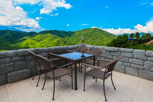 cafe table and chairs with mountain view and blue sky