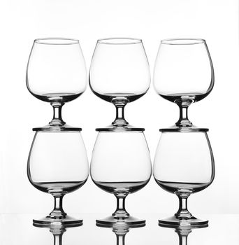 stack of empty wine glass on glass table (gray scale)